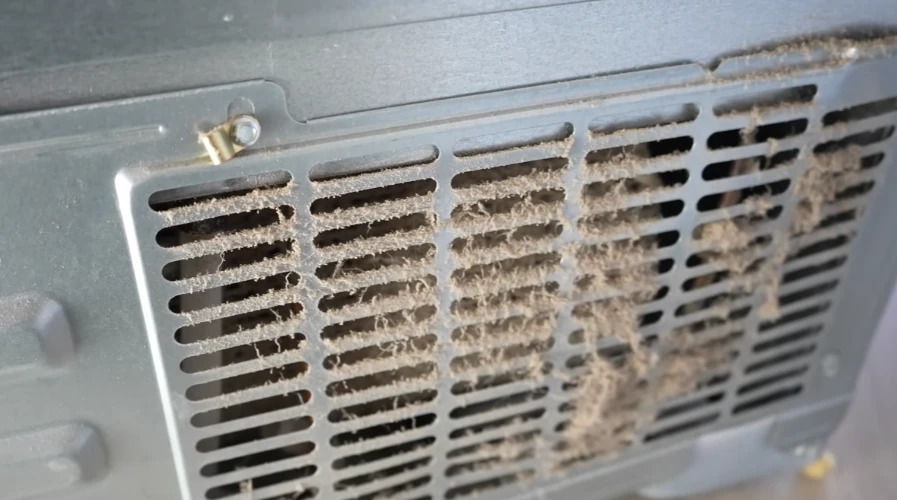 Dusty refrigerator vent showing need for cleaning and maintenance