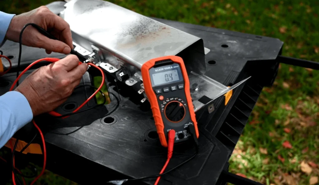 Person checking dryer voltage with electronic multimeter and probes