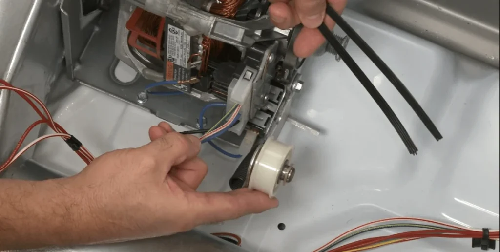 Person repairing belt from back of dryer for repair or maintenance