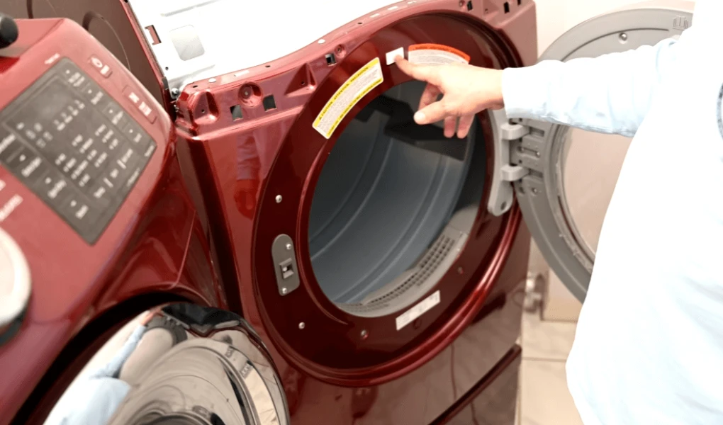 Person beside dryer in laundry room, symbolizing professional dryer repair Pensacola service.