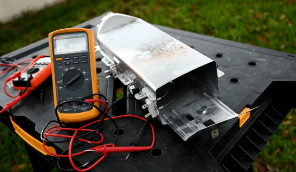 Person using multimeter to measure dryer temperature for proper function