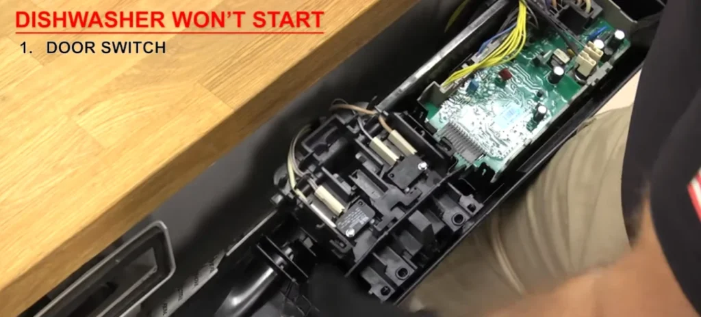 Open dishwasher door showing wires and circuit board with door switch label.