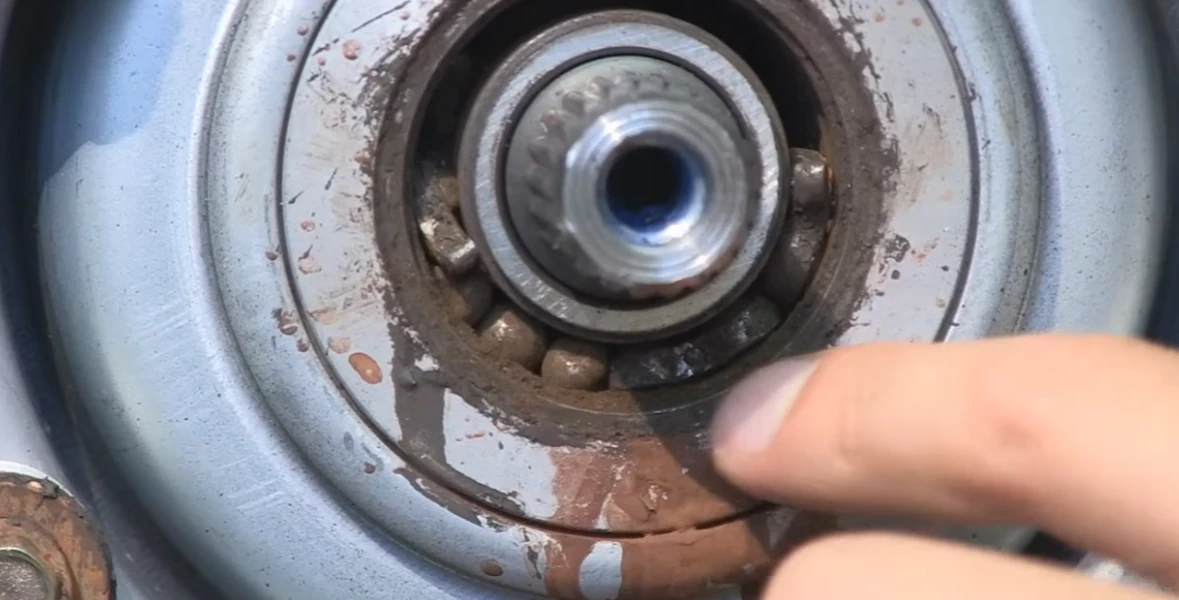 Finger pointing at rusty washing machine bearing